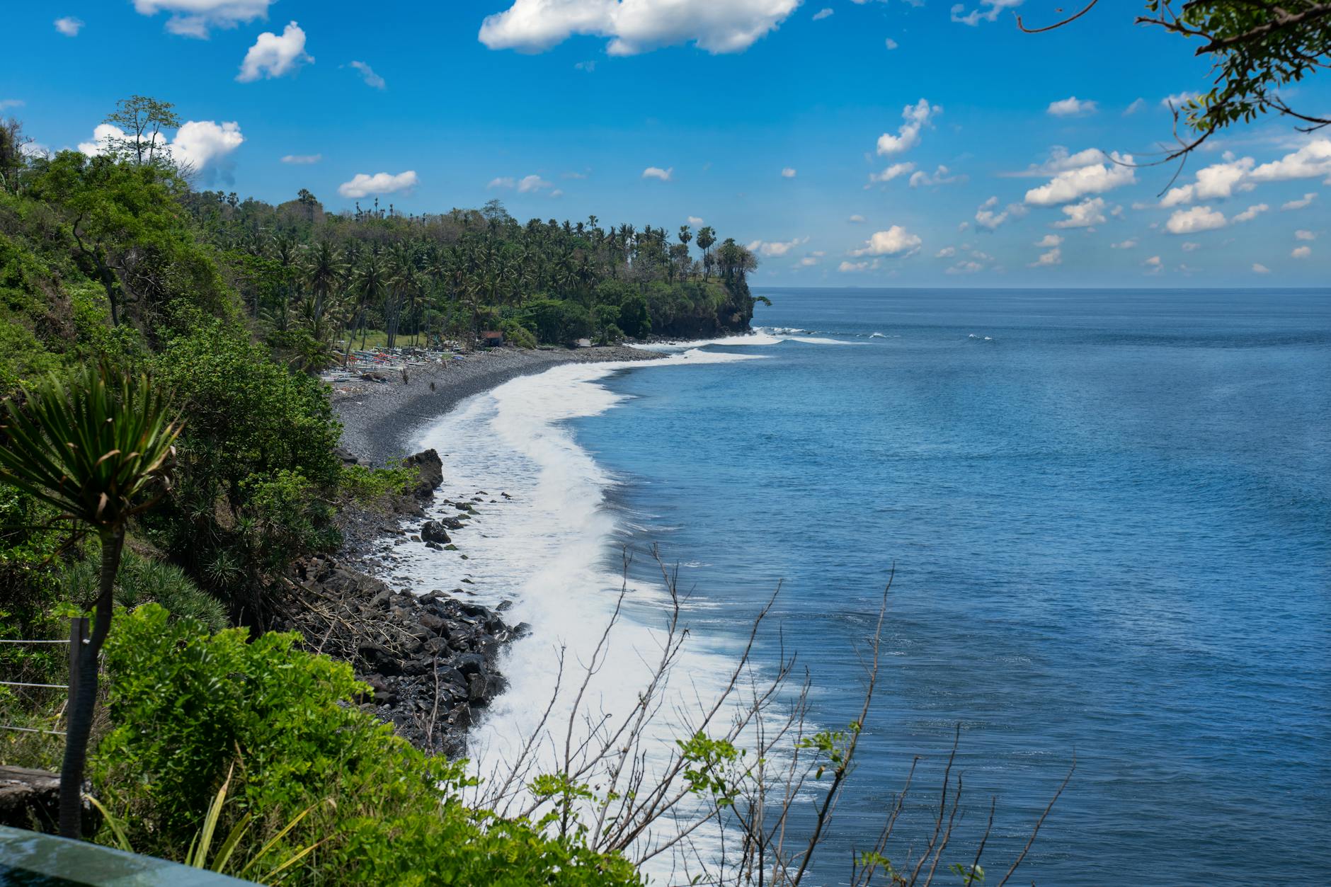Skaliste wybrzeże Bali z zielenią i turkusowym oceanem o zachodzie słońca