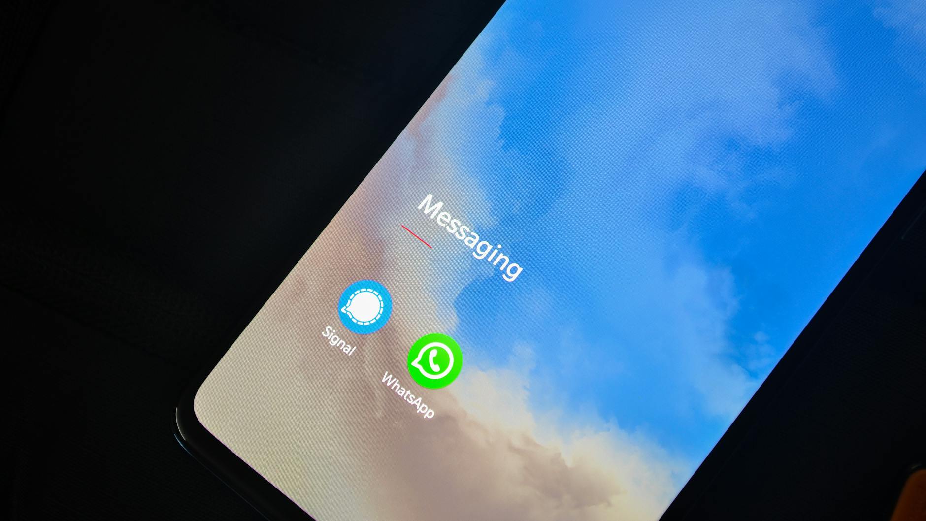 Zbliżenie ekranu smartfona z ikonami komunikatorów Signal i WhatsApp