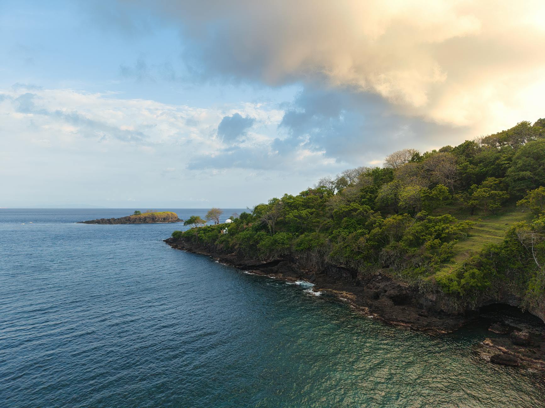 Zielone klify Bali schodzące do oceanu o zachodzie słońca