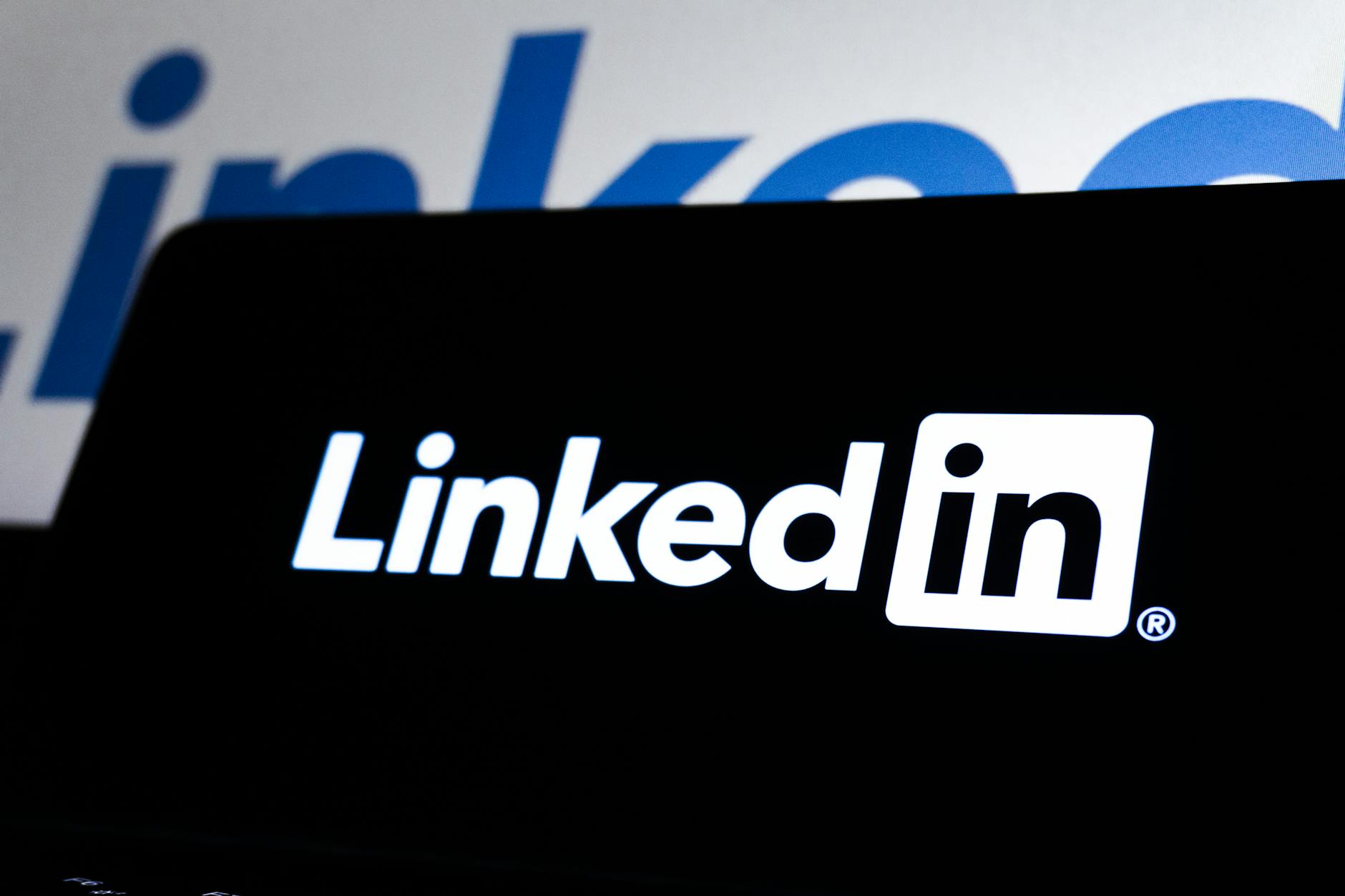 Logo LinkedIn na ciemnym tle symbolizujące zagrożenia w sieci