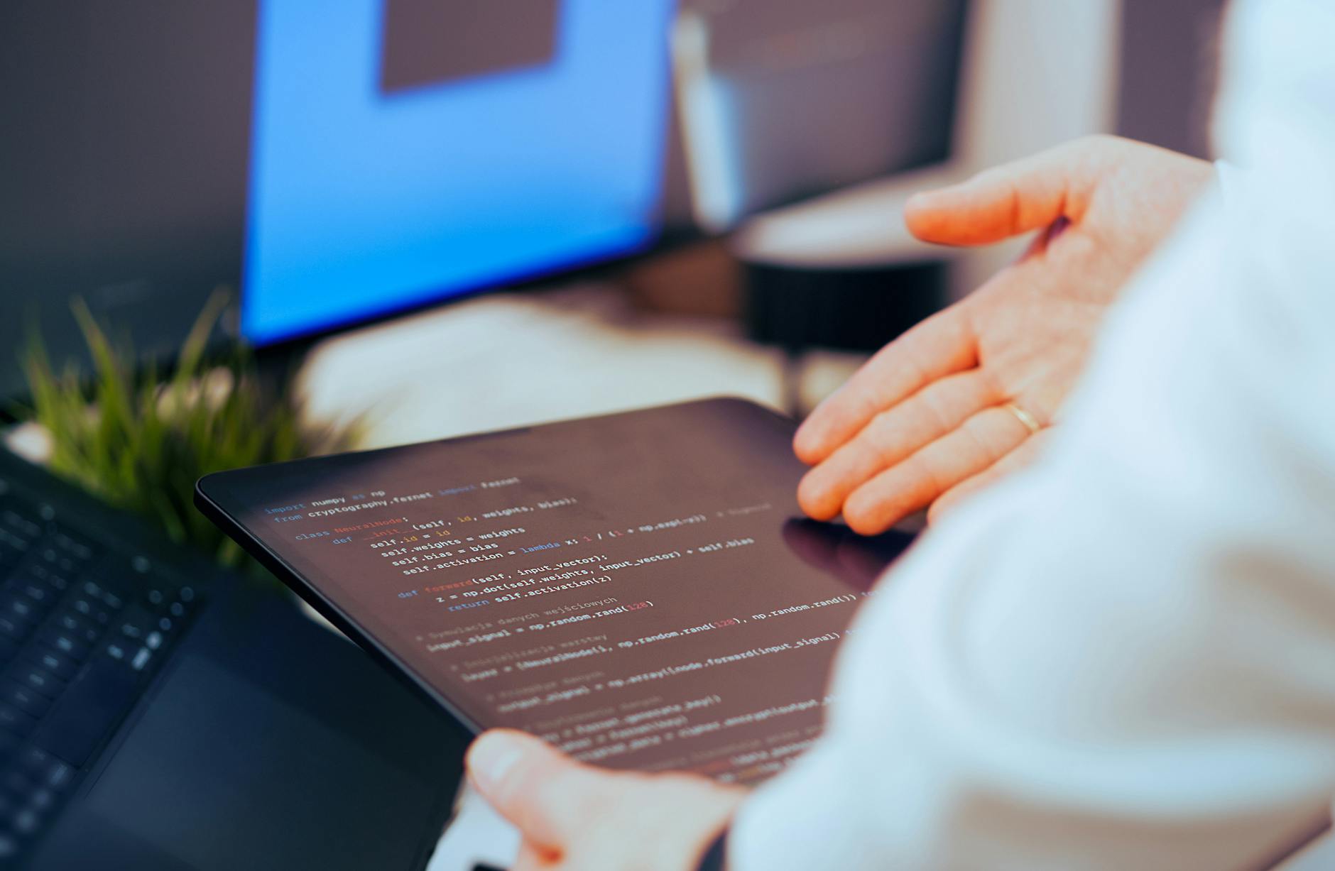 Programista analizuje kod Pythona na tablecie w nowoczesnym biurze
