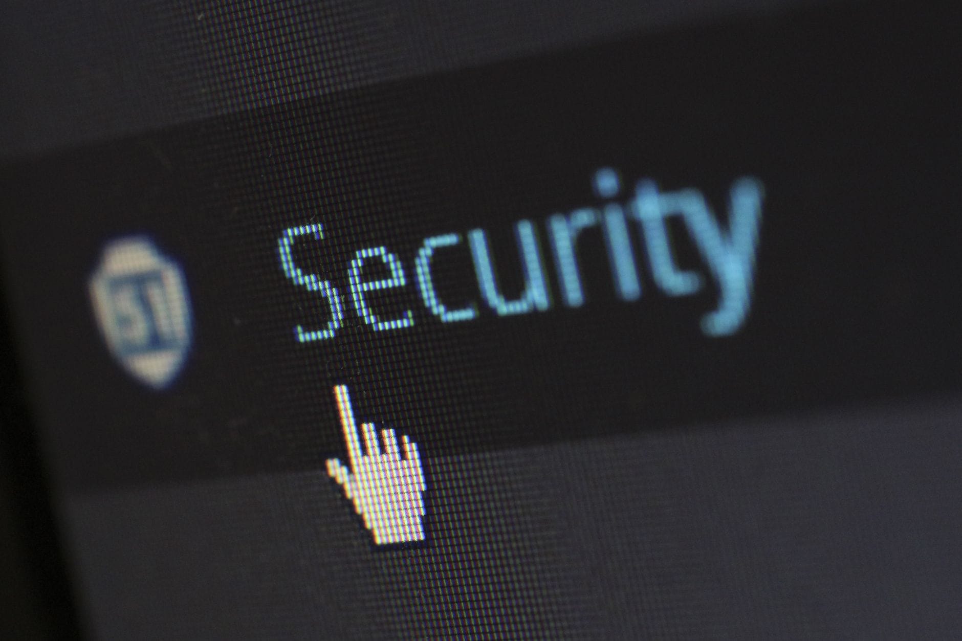 Kursor myszy na tekście o cyberbezpieczeństwie na ekranie monitora