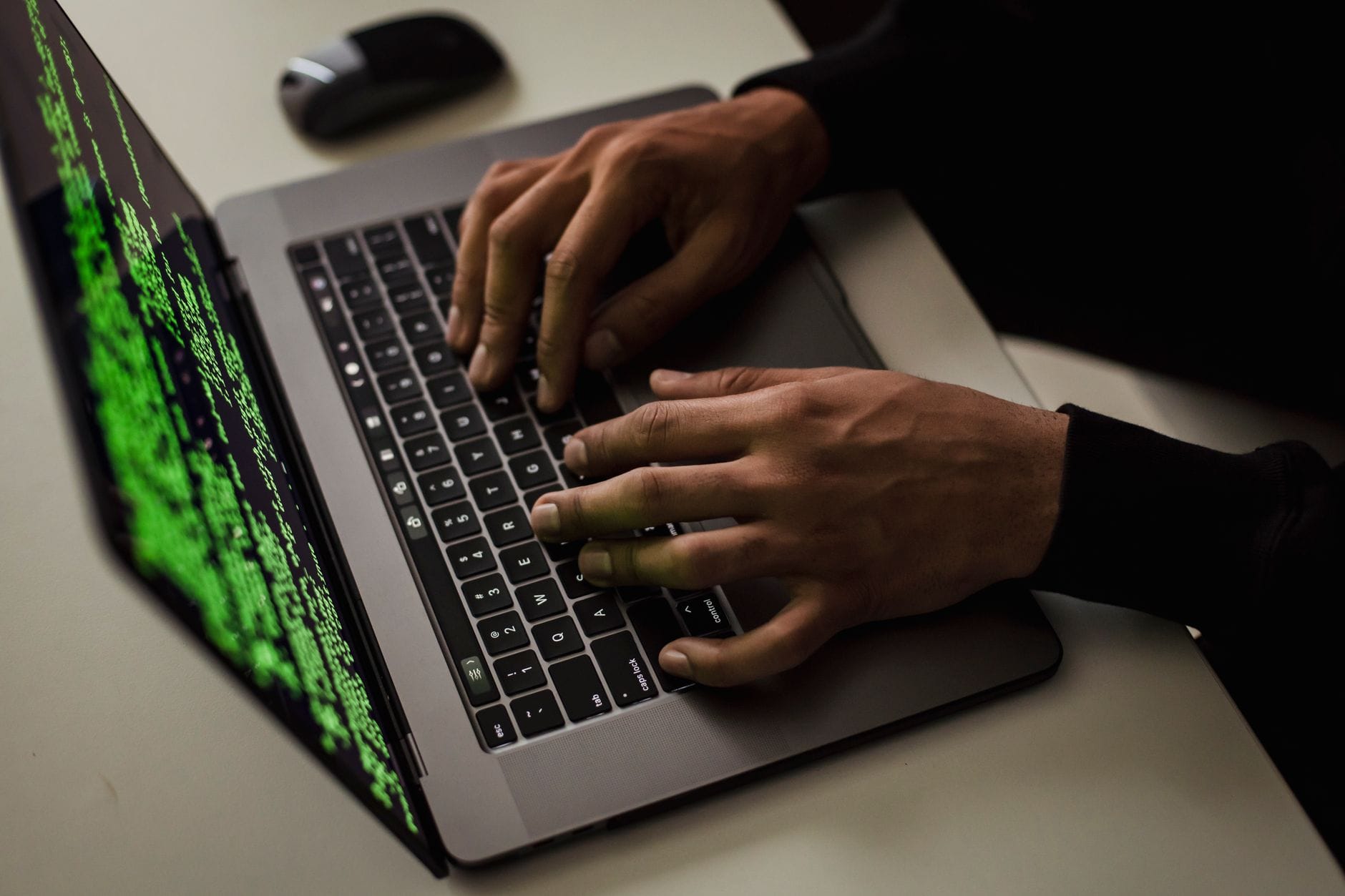 Mężczyzna piszący na netbooku z danymi na ekranie przy biurku