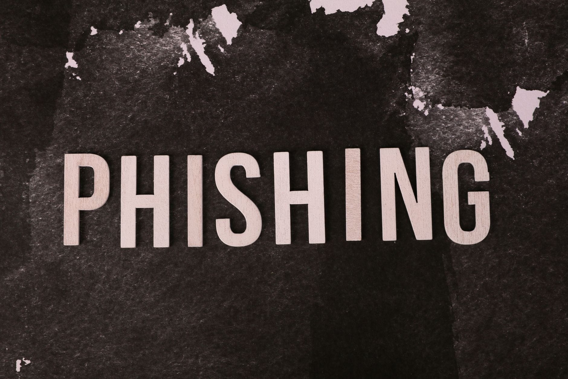 Abstrakcyjny napis phishing na ciemnej, teksturowanej powierzchni